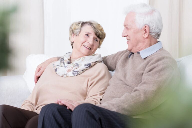 elderly couple looking at each other smiling